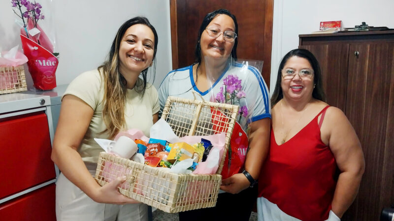 Servidoras Silvana e Cecília, sorteadas na ação de Dia das Mães, retiram cestas e flores no Sinseri